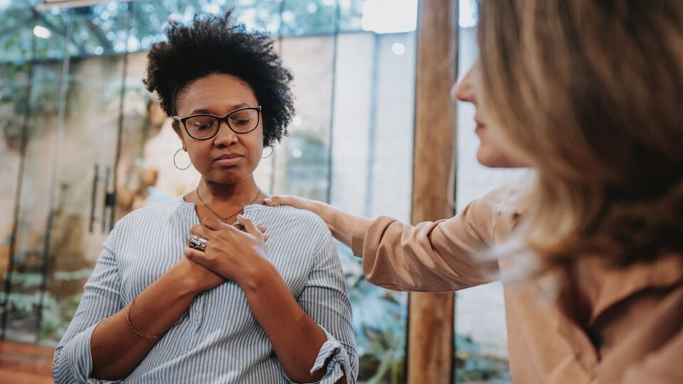 a woman holding her hands on her chest during a One on one therapy session at REACH Ohio