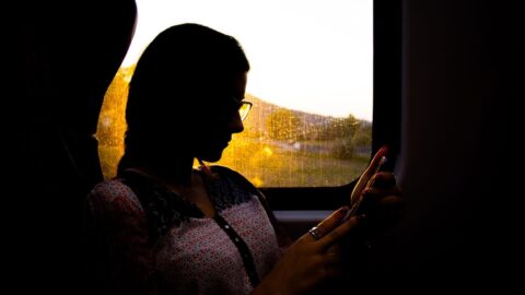 A woman looking at her phone, seeking support and resources for domestic violence counseling. REACH a mental health clinic in Ohio.