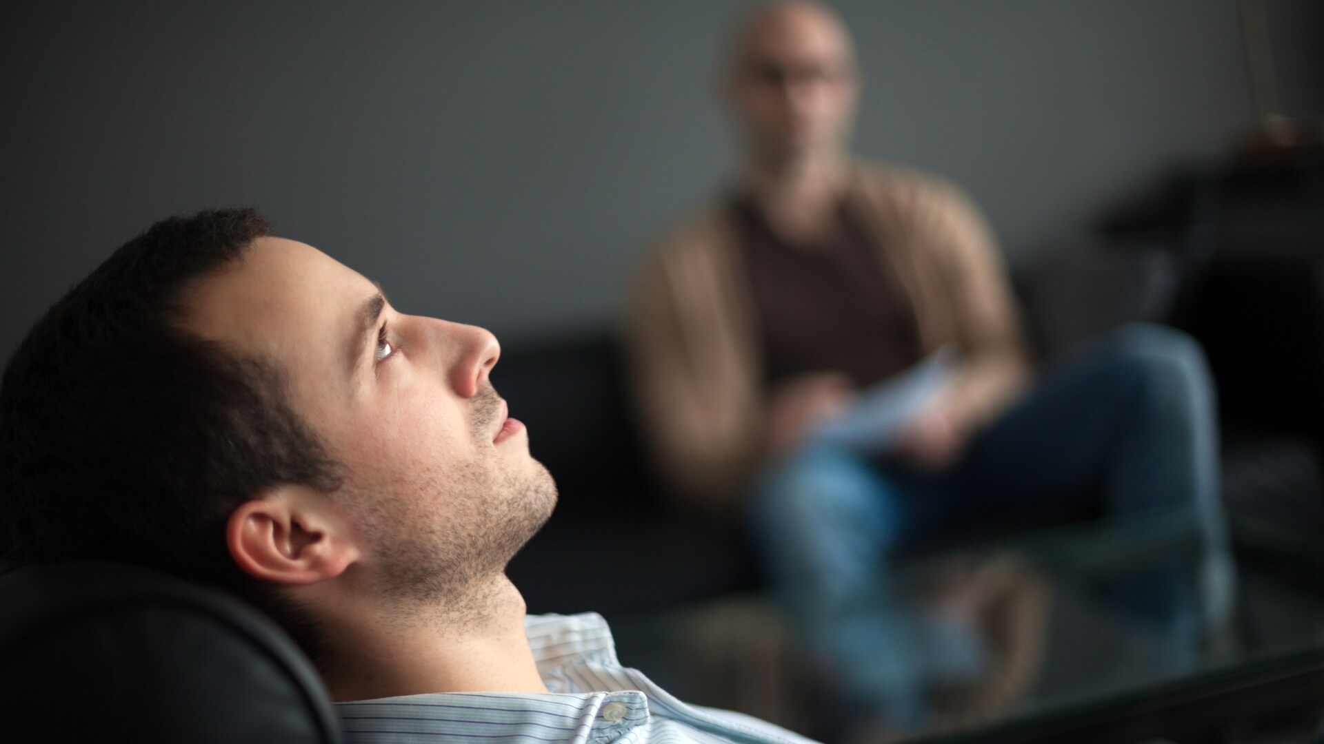 Person lying on a sofa talking to their therapist, showing how to get therapy and that support is possible for everyone.