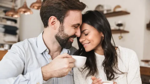 Smiling couple sharing an intimate moment over coffee, portraying emotional closeness — often the very connection people feel afraid of when dealing with fear in relationships