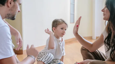 Parents engaging positively with their child during parenting therapy, building stronger co-parenting skills after separation or divorce. REACH behavioral health Ohio