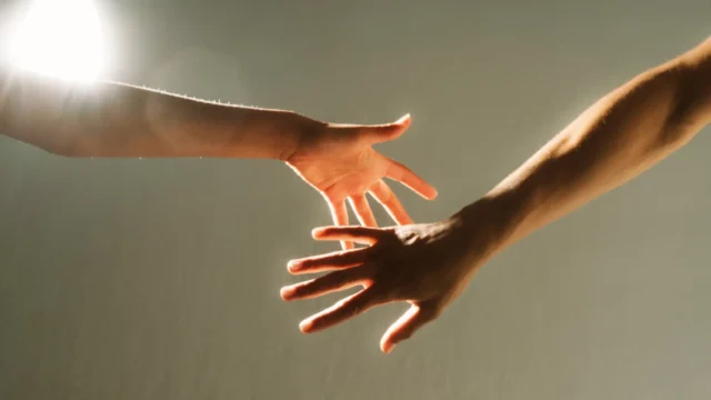 Two hands reaching toward each other, symbolizing support and connection, illustrating facts about depression, how to overcome it, and REACH Behavioral Health support.