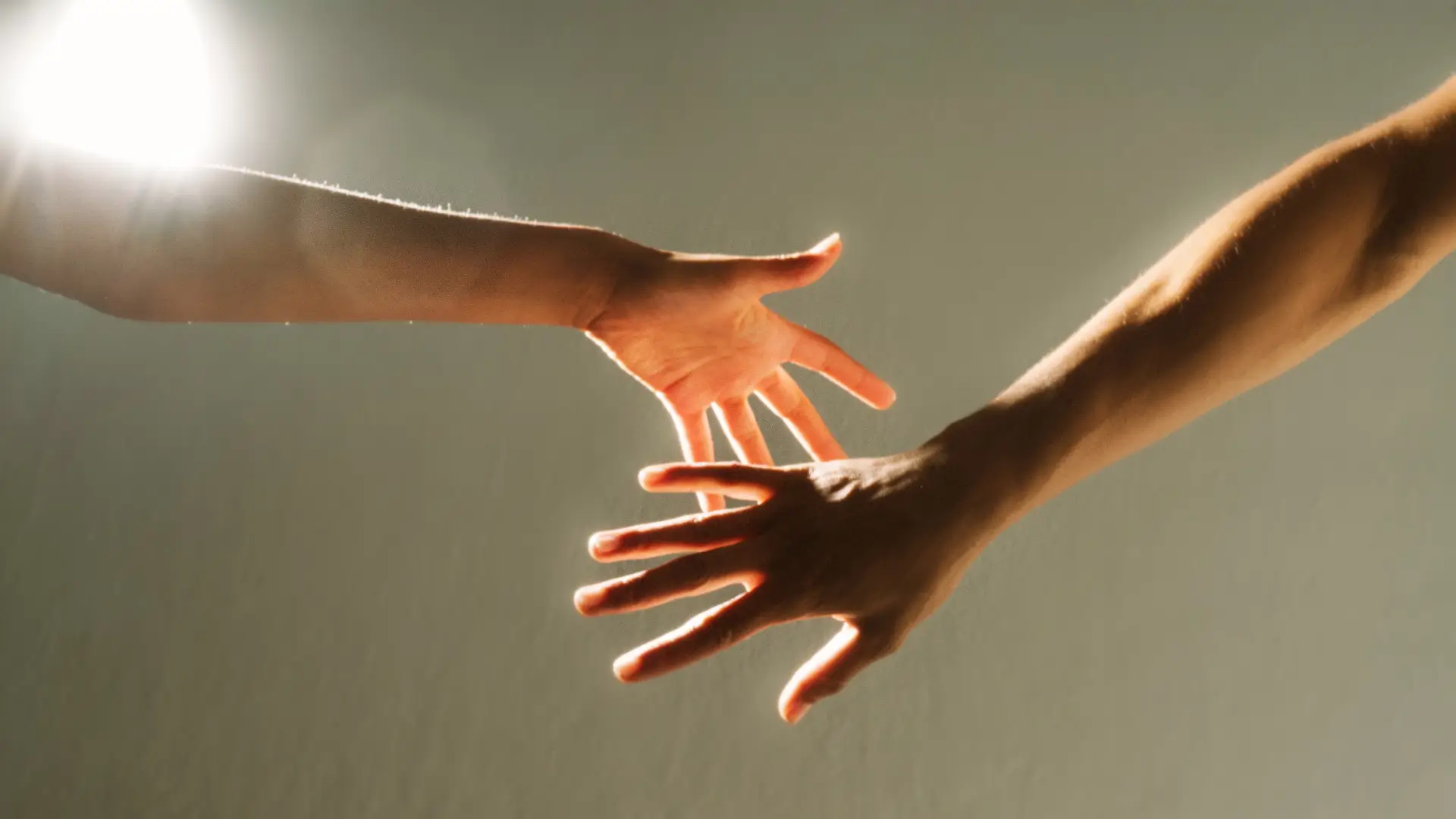 Two hands reaching toward each other, symbolizing support and connection, illustrating facts about depression, how to overcome it, and REACH Behavioral Health support.