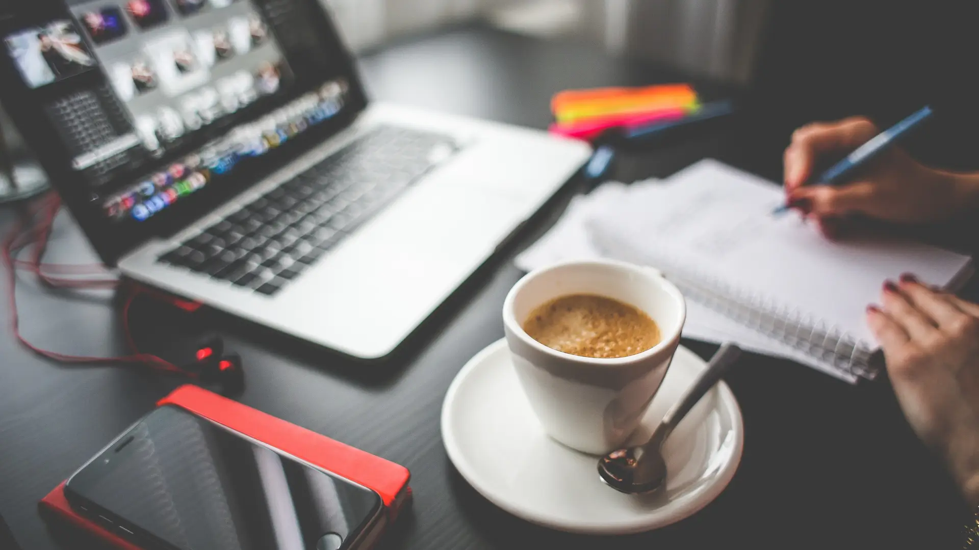 Workspace with a laptop, notebook, phone, and coffee cup, symbolizing research into the Best Treatment for Autism and how ongoing support helps autistic adults in daily life and work.