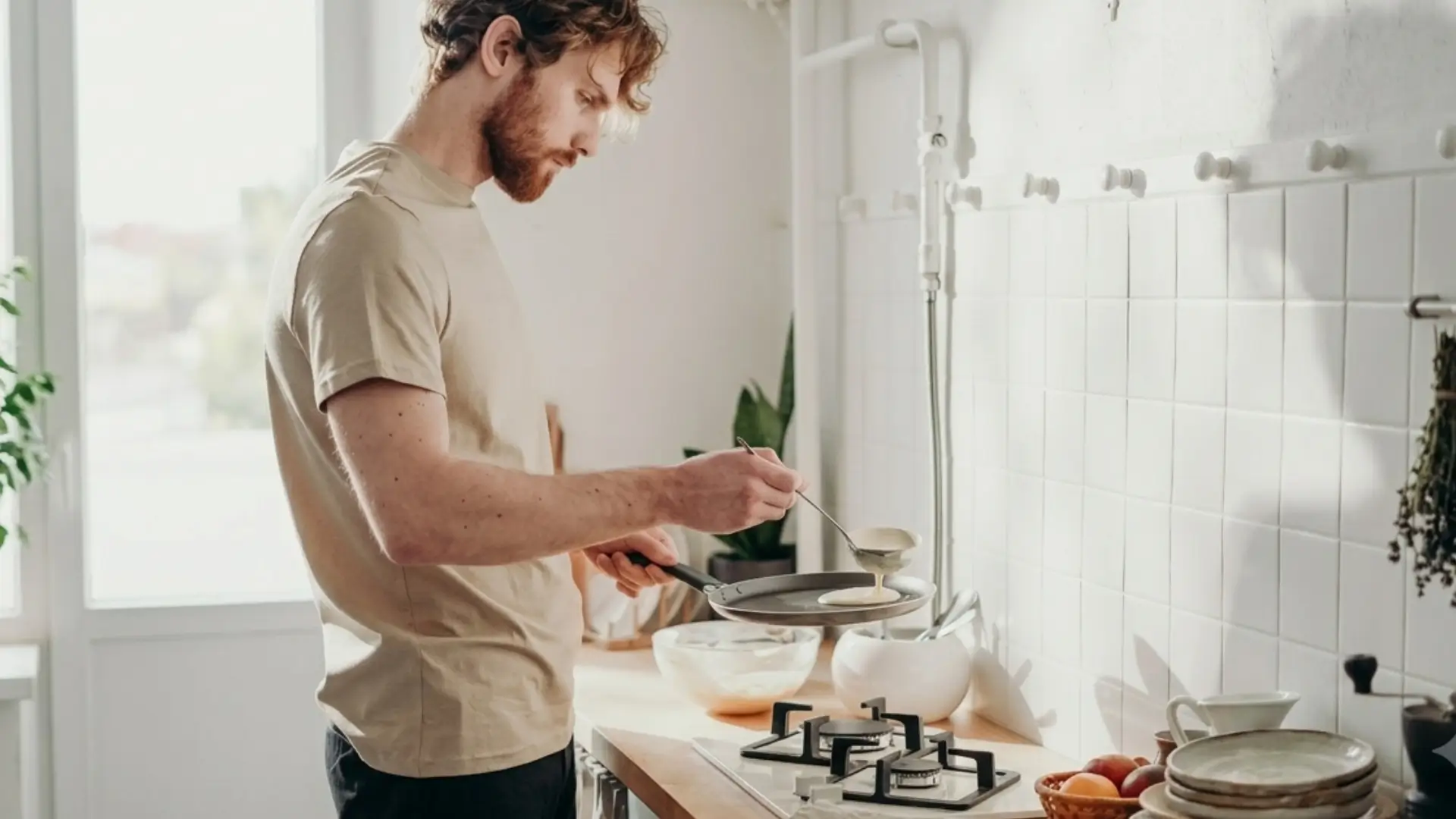 Adult with autism practicing independent cooking skills in a home kitchen during ABA therapy. REACH behavioral health